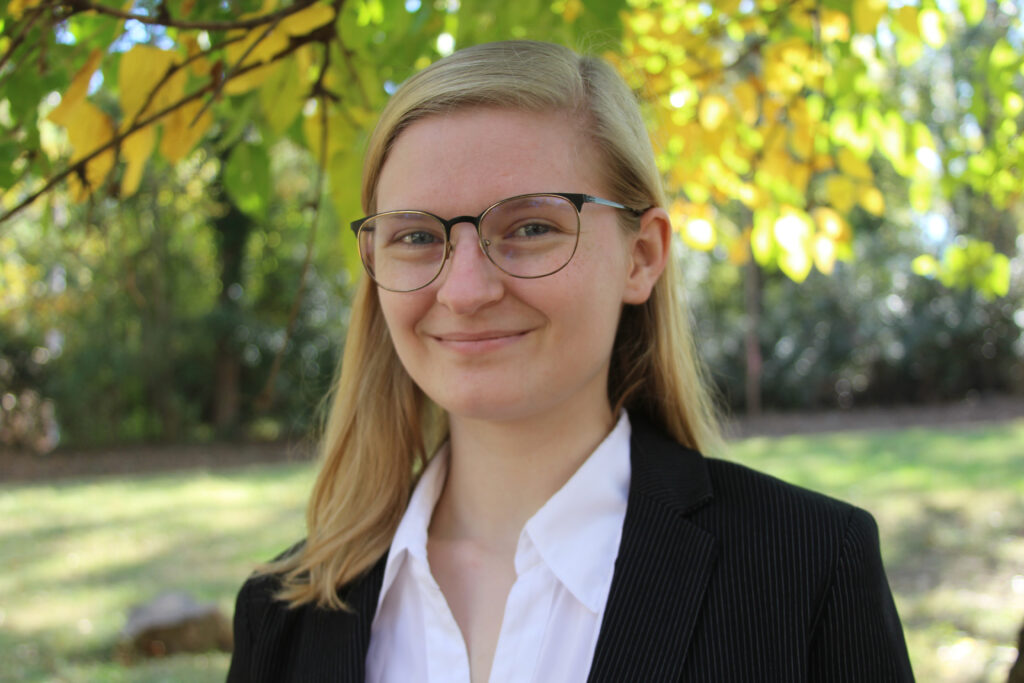 headshot of Casey against a background of greenery